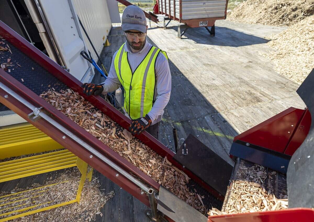 Kurtis Gubnitsky, an operations manager with Clean Earth Innovations, watches as wood chips are fed into a conveyor belt to be turned into biochar during the launch of the company's pilot program at the South Dade Landfill on Friday, Feb. 6, 2025, in Homestead, Fla.