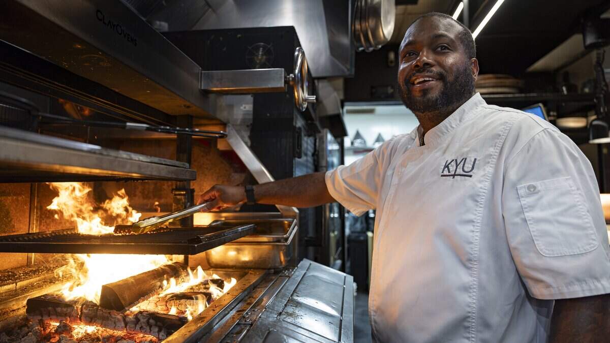 Chef Raheem Sealey prepares a grilled octopus at his restaurant, KYU, on Wednesday, Aug. 26, 2026, in Miami, Fla.