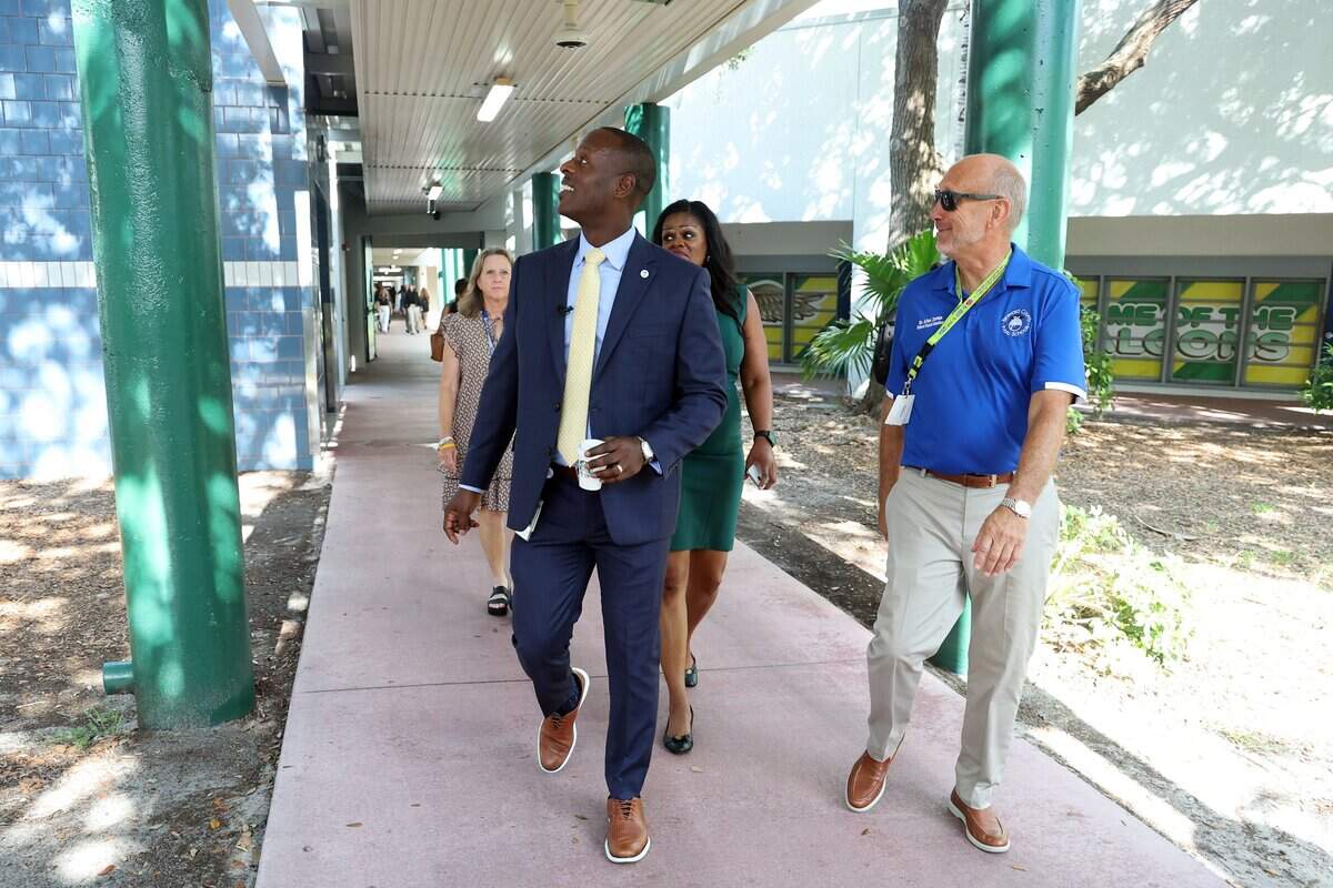 Superintendent Howard Hepburn and school board members Debra Hixon, left, and Allen Zeman walk through Sunrise Middle School in Fort Lauderdale on the first day of school on Monday, Aug. 10, 2026.
