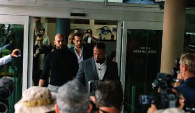 Andrew Tate, left in black, and his brother Tristan Tate, center rear, arrive at Fort Lauderdale-Hollywood International Airport in Florida on Feb. 27, 2025.