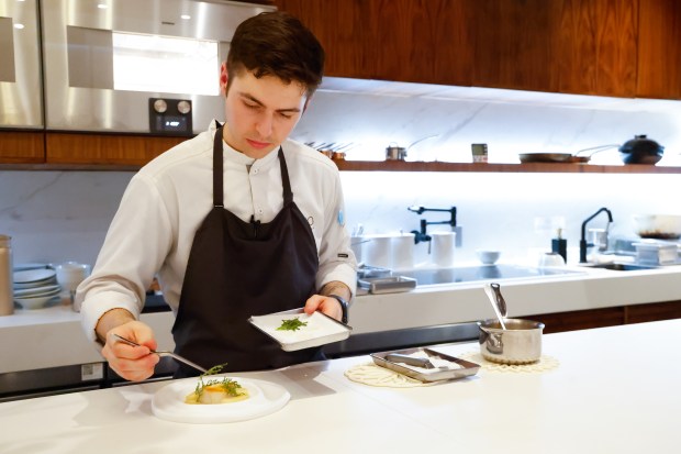 Omo by Jont Sous Chef Tanner O'Ben adds a finishing touch to a black cod dish with California sake, clams and turnips at the Michelin-starred restaurant in Winter Park. (Rich Pope/ Orlando Sentinel)