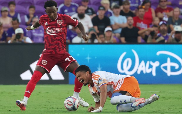Cincinnati player Evander (bottom) takes a spill in front of Orlando player Ivan Angulo (77) during the FC Cincinnati at Orlando City MLS Soccer match at Inter.co Stadium in Orlando on Saturday, August 15, 2026. (Stephen M. Dowell/Orlando Sentinel)