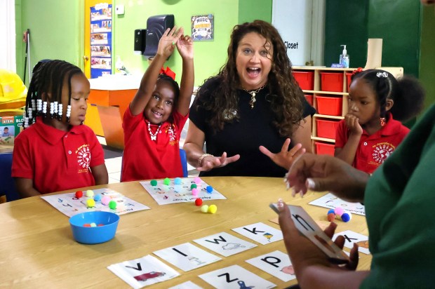 Jamie Dozier with the REED Charitable Foundation cheers pre-schooler McKenzie Wood, second from left, during an alphabet exercise at Nu Generation Academy in Orlando, Monday, August 10, 2026. REED Charitable a literacy and education training non-profit was a primary beneficiary of Visit Orlando's Magical Dining event in 2025. The annual dining program showcases more than 160 restaurants featuring prix-fixe menus with a portion of proceeds going to local charities. (Joe Burbank/Orlando Sentinel)