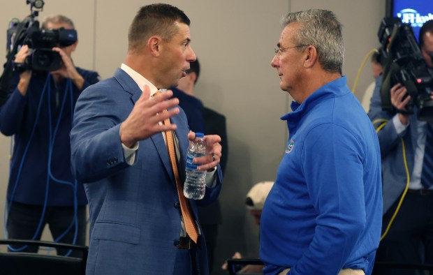 Florida coach Jon Sumrall, left, chats with former Gators coach Urban Meyer after Sumrall was introduced Dec. 1 at the University of Florida in Gainesville. (Stephen M. Dowell/Orlando Sentinel)