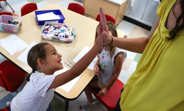 Four-year-old Gabriella Gallup gets a high-five from center director Jessica Lopez in the VPK class at Goldenrod Road KinderCare in Winter Park, Wednesday, Aug. 26, 2026. Florida's VPK program has been linked to higher levels of kindergarten readiness. (Joe Burbank/Orlando Sentinel)
