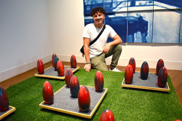 Artist Justin Quaid Grubb is photographed next to his sculptural works during opening night of the "Experience Contemporary: A Wrench in the Gears" exhibition at Casselberry Arts Center. (Chelsea Smith/Courtesy of Casselberry Arts)