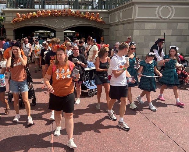 Walt Disney World visitors, some in holiday costumes, work their way into Magic Kingdom theme park for early admittance to Mickey's Not-So-Scary Halloween Party, an after-hours event with exclusive offerings and shows. (Dewayne Bevil/Orlando Sentinel)
