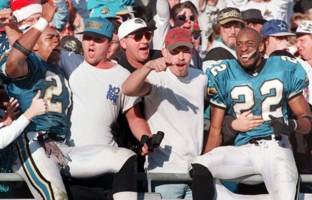Jacksonville Jaguars players Aaron Beasley (21) and Bucky Brooks (22) celebrate in the stands with fans after beating the Atlanta Falcons 19-17 at Jacksonville Municipal Stadium, Sunday, Dec. 22, 1996. (AP Photo/The Florida Times-Union, Will Dickey)