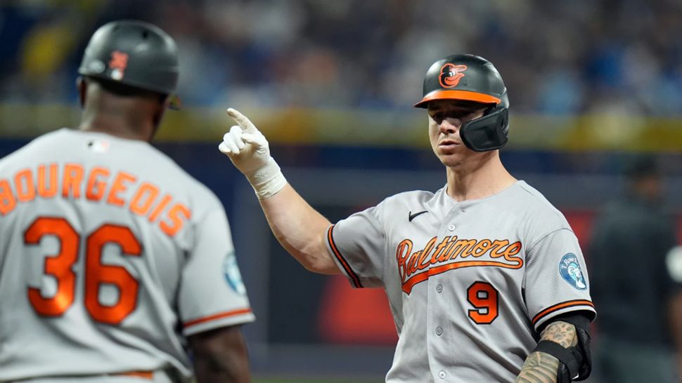 Baltimore Orioles' Tyler O'Neill (9) celebrates with first base coach Jason Bourgeois (36) after his RBI single off Tampa Bay Rays pitcher Bryan Baker during the 10th inning of a baseball game Saturday, Aug. 15, 2026, in St. Petersburg, Fla. (AP Photo/Chris O'Meara)