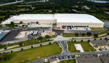 Aerial view of the Ashley Furniture warehouse and distribution center in Brandon, with loading docks and trailers.