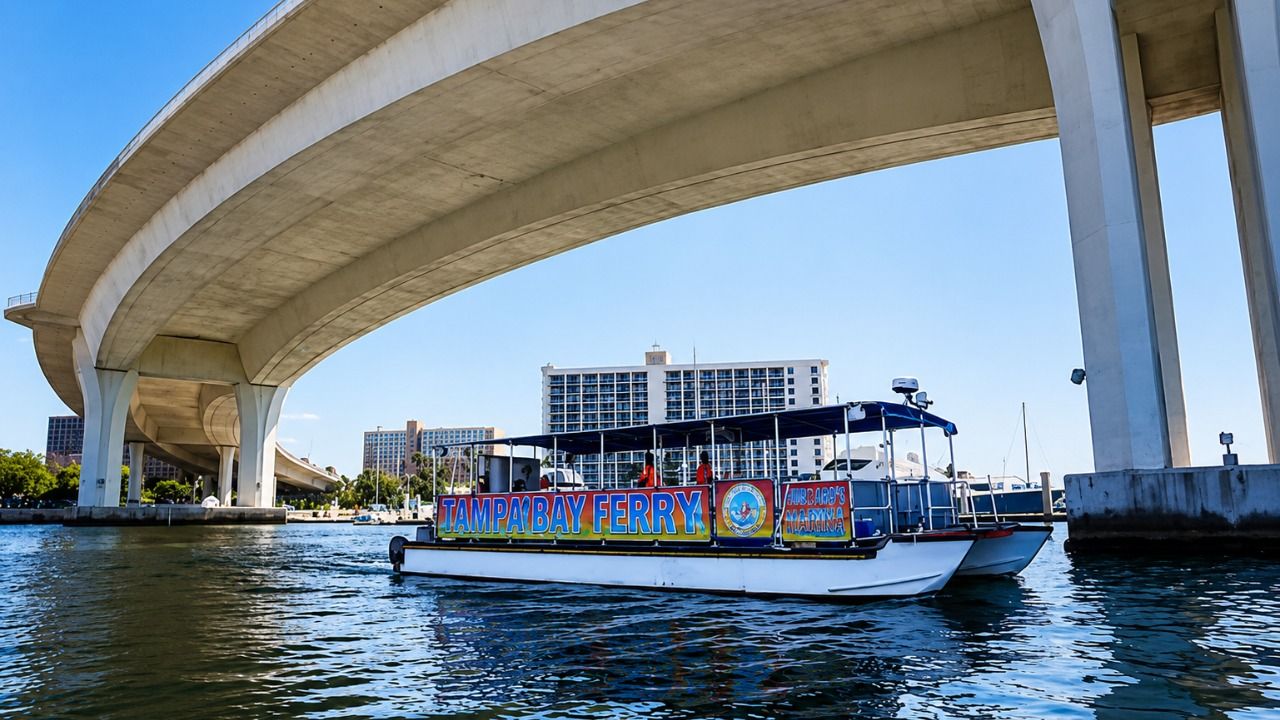 Tampa Bay Ferry vessel travels beneath a bridge in Tampa Bay.