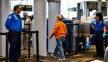 TSA officers oversee a passenger walking through a security checkpoint at Tampa International Airport.