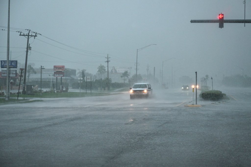A car drives through heavy rain in Fort Myers, Florida, as Hurricane Milton approaches.