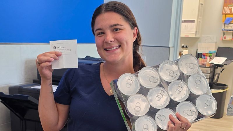 Brianna Novy, HSTC’s canine team lead employee, holds a gift receipt from a generous person who sent in donations. Surrounding her is a room full of donations from the community. (Humane Society of the Treasure Coast)