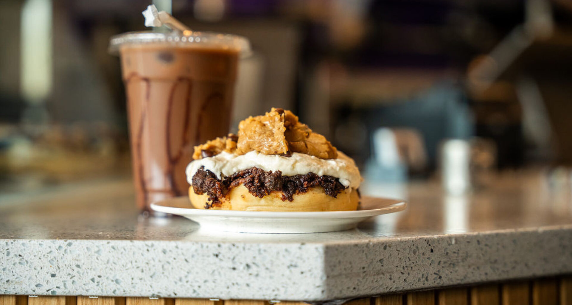 a cinaholic cinnamin bun and drink on a counter