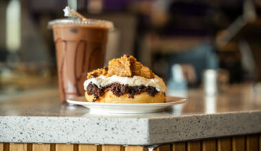 a cinaholic cinnamin bun and drink on a counter