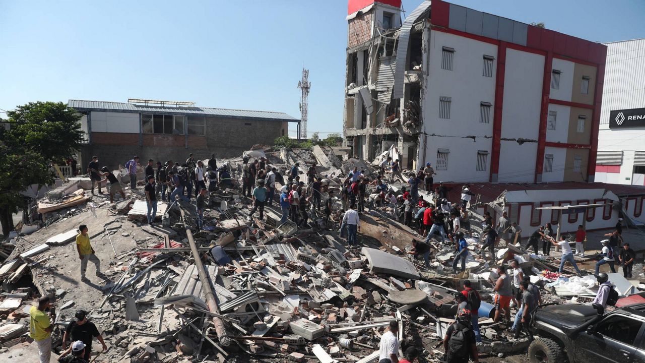 Residents and rescue workers search through the rubble of a collapsed building after an earthquake struck Cali, Colombia, Monday, Aug. 10, 2026. (AP Photo/Santiago Saldarriaga)