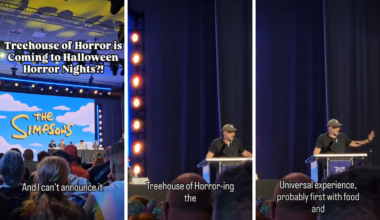 Creators of the Simpsons sitting at a table and podium on a stage in front of a screen displaying the Simpsons logo.