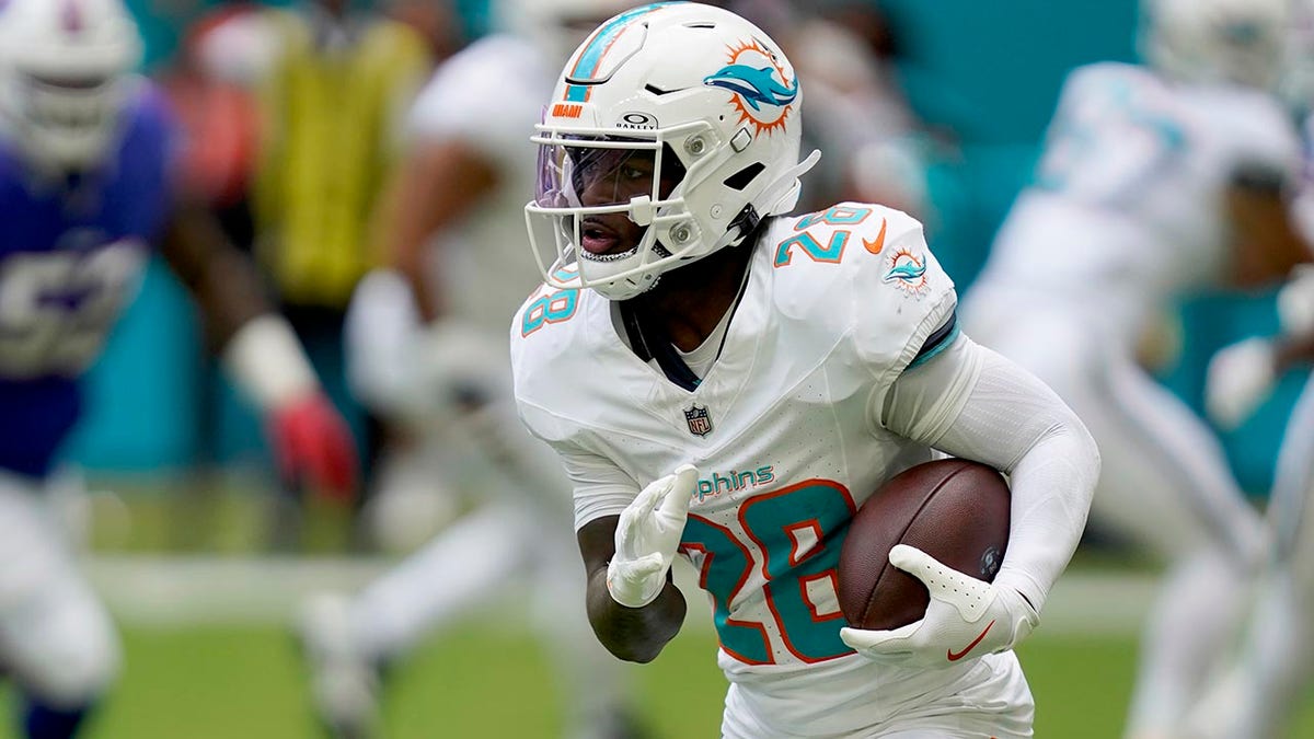 Miami Dolphins running back De'Von Achane runs with football