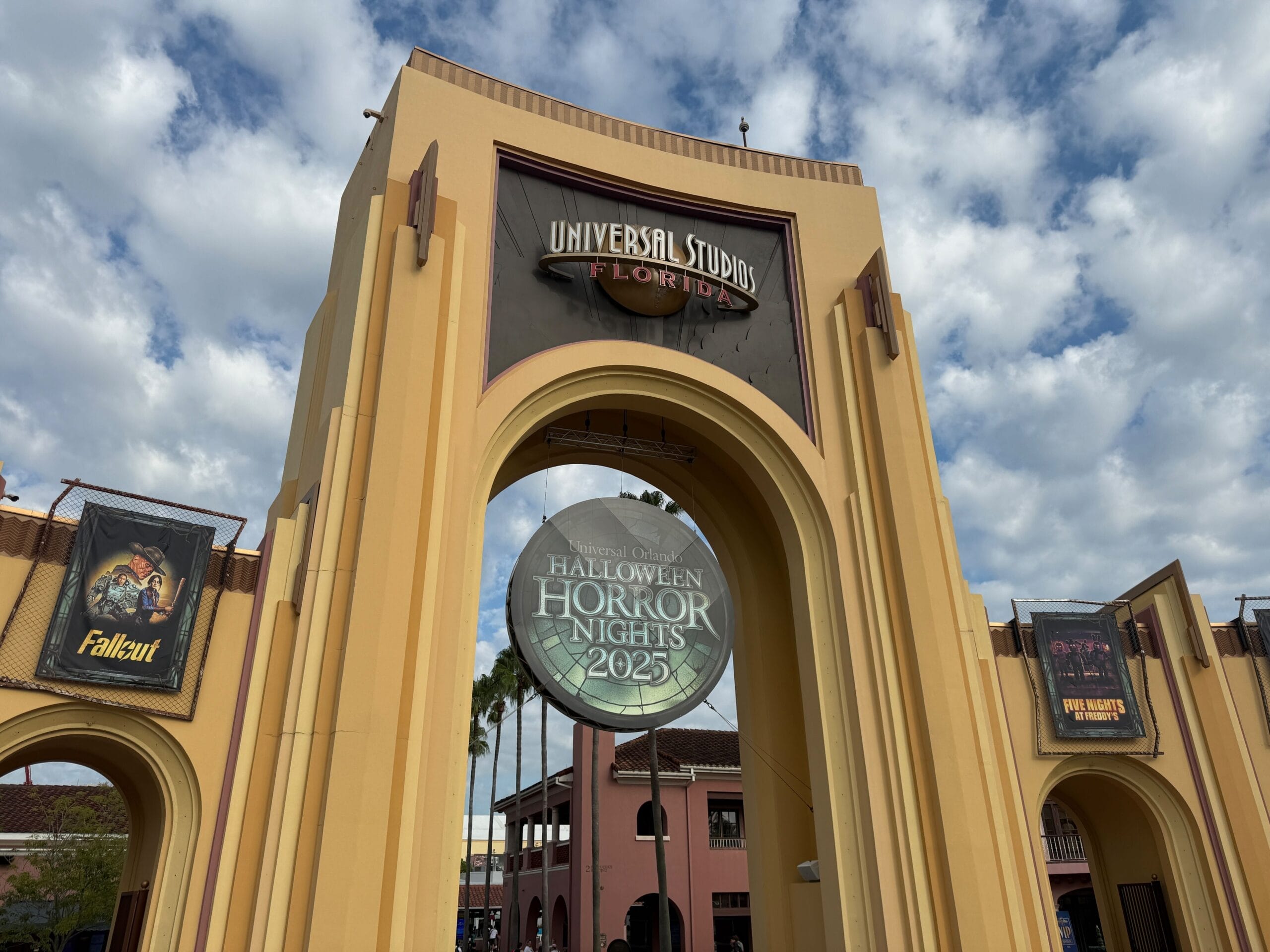 Entrance archway of Universal Studios Florida with a Halloween Horror Nights 2025 sign and Halloween Horror Nights Map banners.