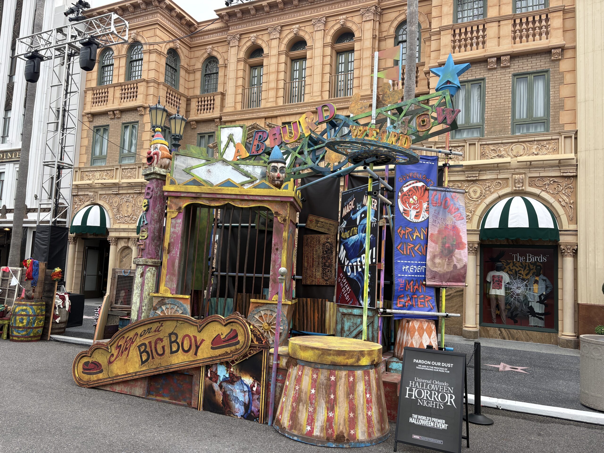 We've seen more and more carnival-esque props show up in recent weeks in what we have determined to be the Hollywood: Sideshow of Decay scare zone. In our last update, the above stage area was still surrounded by gates, so we weren't able to see all of the elements near the bottom of the stage. Additional signage has also gone up, such as The Man Eater and Magic Maker signs seen on the right side of the stage area.