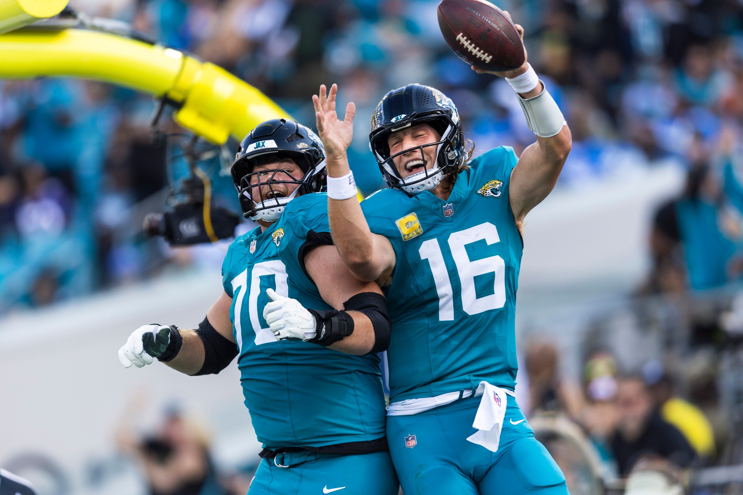 Nov 16, 2025; Jacksonville, Florida, USA; Jacksonville Jaguars quarterback Trevor Lawrence (16) celebrates with offensive tackle Cole Van Lanen (70) after rushing for a touchdown against the Los Angeles Chargers during the third quarter at EverBank Stadium. Mandatory Credit: Morgan Tencza-Imagn Images