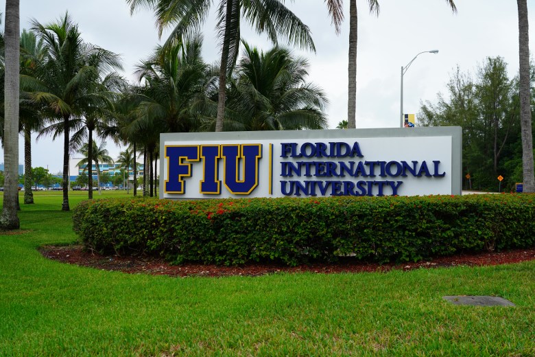 Entrance sign for Florida International University (FIU) surrounded by palm trees in Miami, Florida.