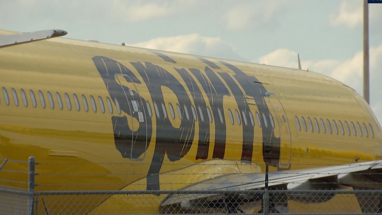 The right side of a parked yellow plane reveals the Spirit Airlines logo. (Spectrum News)