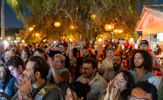 Attendees cheer during one of the speeches at the Chomp The Oligarchy rally at Sidewalk Bottleshop in Fort Lauderdale on Friday, Aug. 14, 2026. (Matias J. Ocner/Miami Herald)