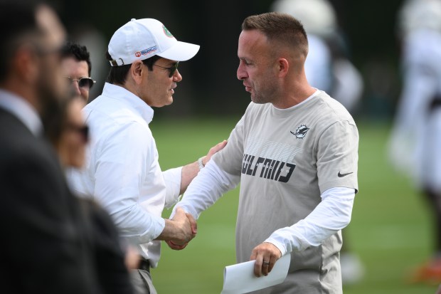 U.S. Secretary of State Marco Rubio, left, shakes hands with Miami Dolphins head coach Jeff Hafley, right, before a joint practice between the Washington Commanders and the Dolphins at NFL football training camp, Wednesday, Aug. 12, 2026 in Ashburn, Va. (AP Photo/Nick Wass)