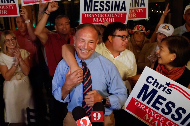 Orange County mayoral candidate Chris Messina gets a hug from his son while celebrating with his wife, Julie, family, friends and supporters following the projected election result during an election night watch party at Gills Lakeside in Orlando on Tuesday, August 18 2026. (Rich Pope/Orlando Sentinel)