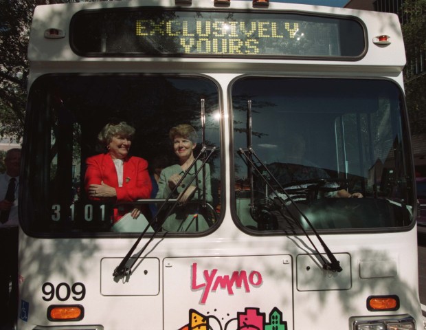 Orange County Chairman Linda Chapin and Orlando Mayor Glenda Hood hop on a bus during the first day of downtown Orlando's new shuttle service Lymmo in August 1997. (Orlando Sentinel file)