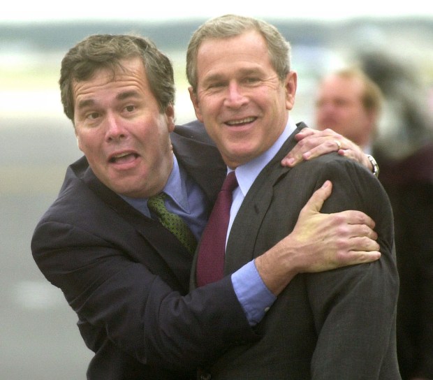 Florida Gov. Jeb Bush jokes with his brother, President George W. Bush, as the newly sworn-in president steps off Air Force One at Orlando International Airport in 2001. (Joe Burbank/Orlando Sentinel file)