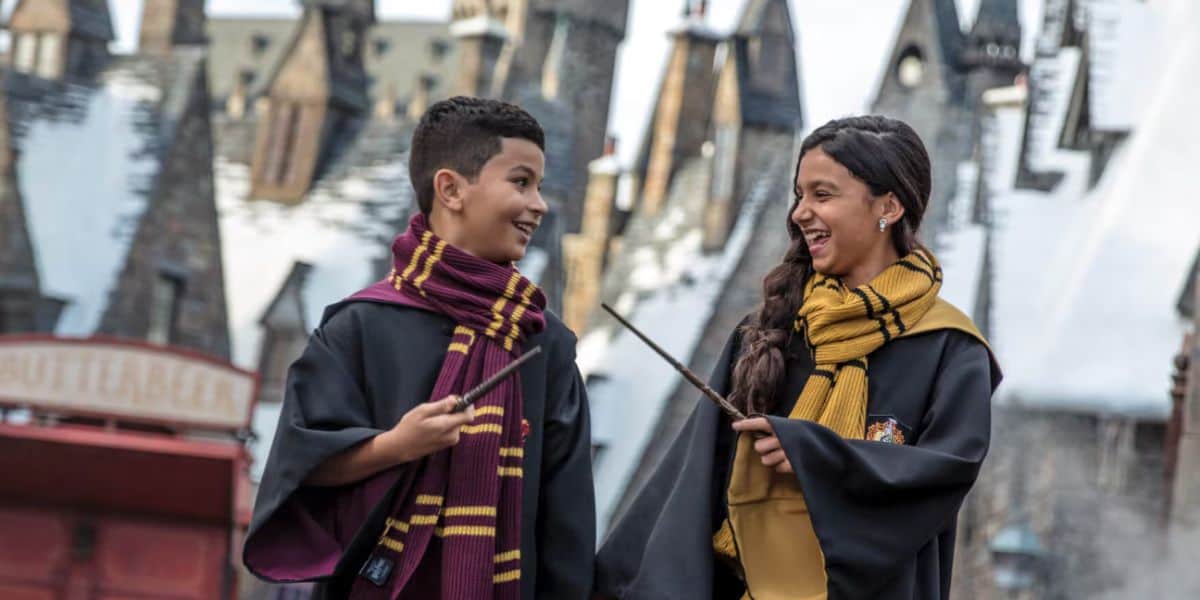 guests in wizard robes with wands in Hogsmeade at Universal Orlando's Wizarding World of Harry Potter