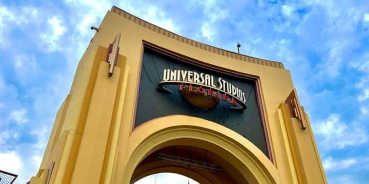 Universal Studios Florida entrance arch covered by construction scrim displaying updated park branding ahead of Halloween Horror Nights 35.