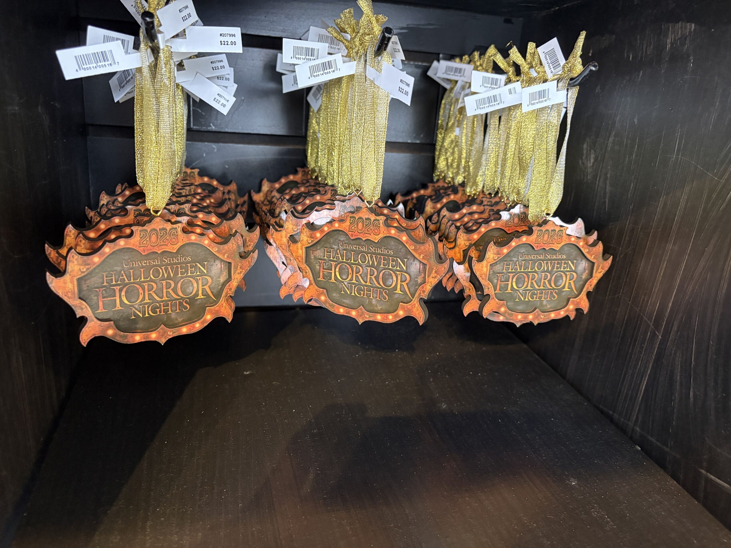 The ornament is the event logo, similar to the front of the t-shirt. It hangs from a shiny gold ribbon.