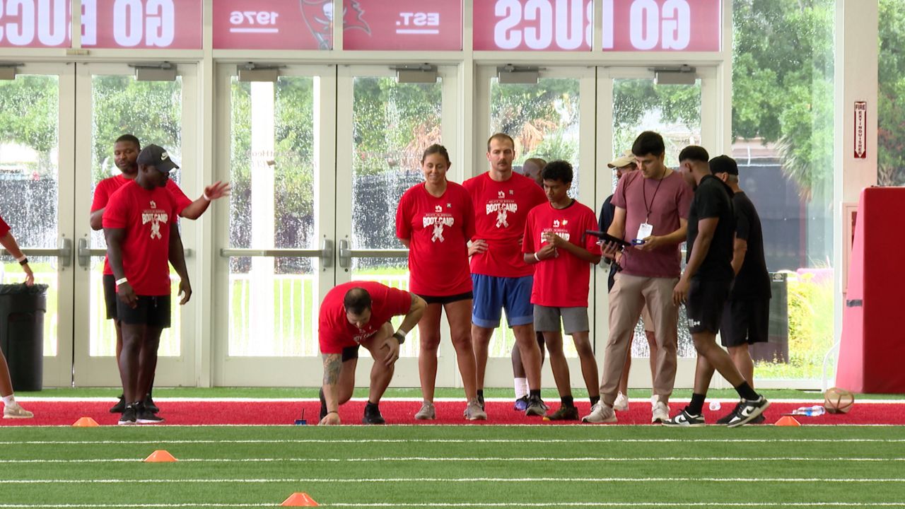 Active duty military members prepare for the 40-yard-dash at the USAA's Salute to Service NFL Boot Camp at the Tampa Bay Buccaneers' AdventHealth Training Center. (Spectrum News/Michael Epps)