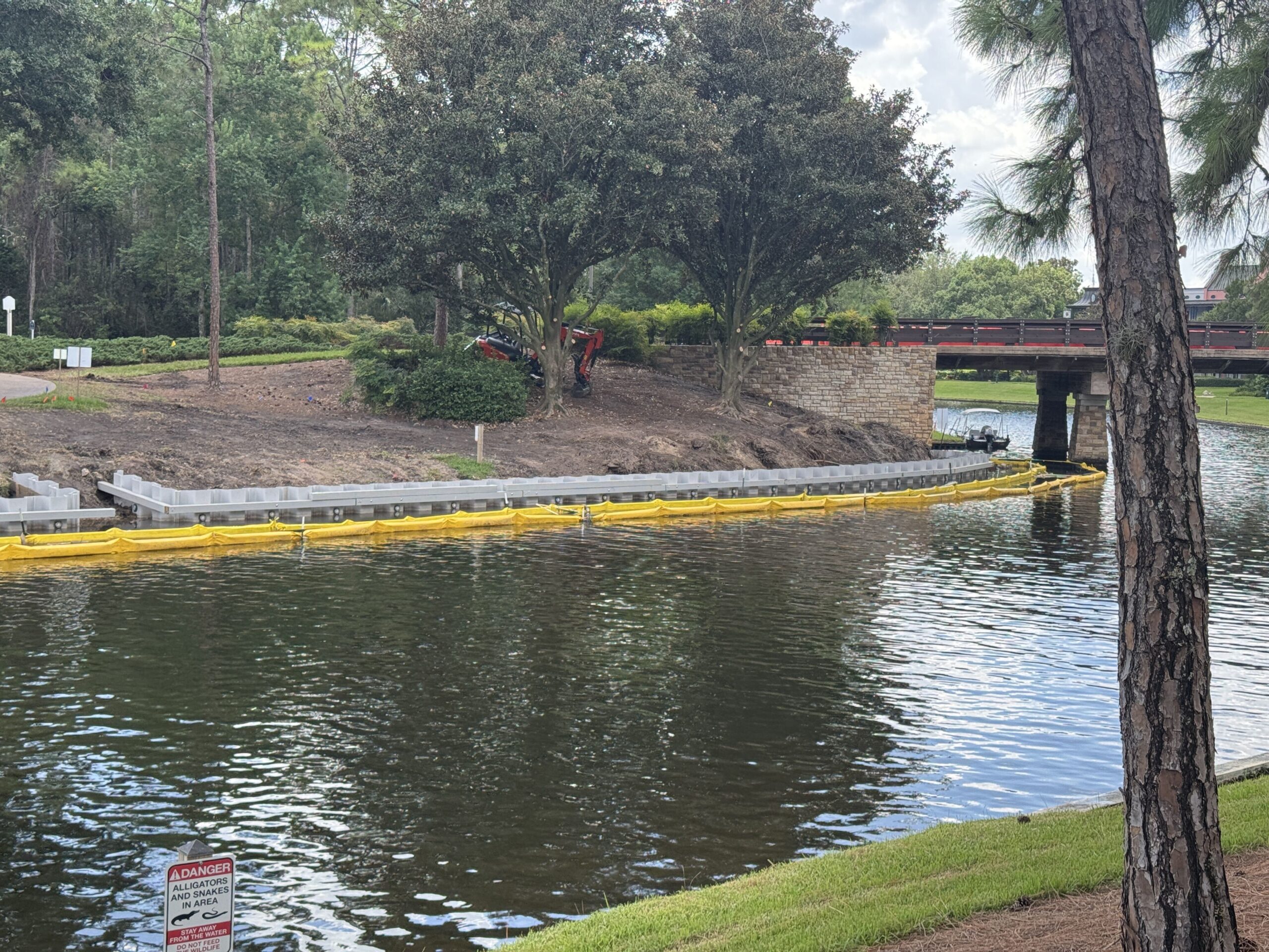 New metal pieces run from under the bridge between the two resorts into Riverside. The yellow barriers in the water help catch debris.