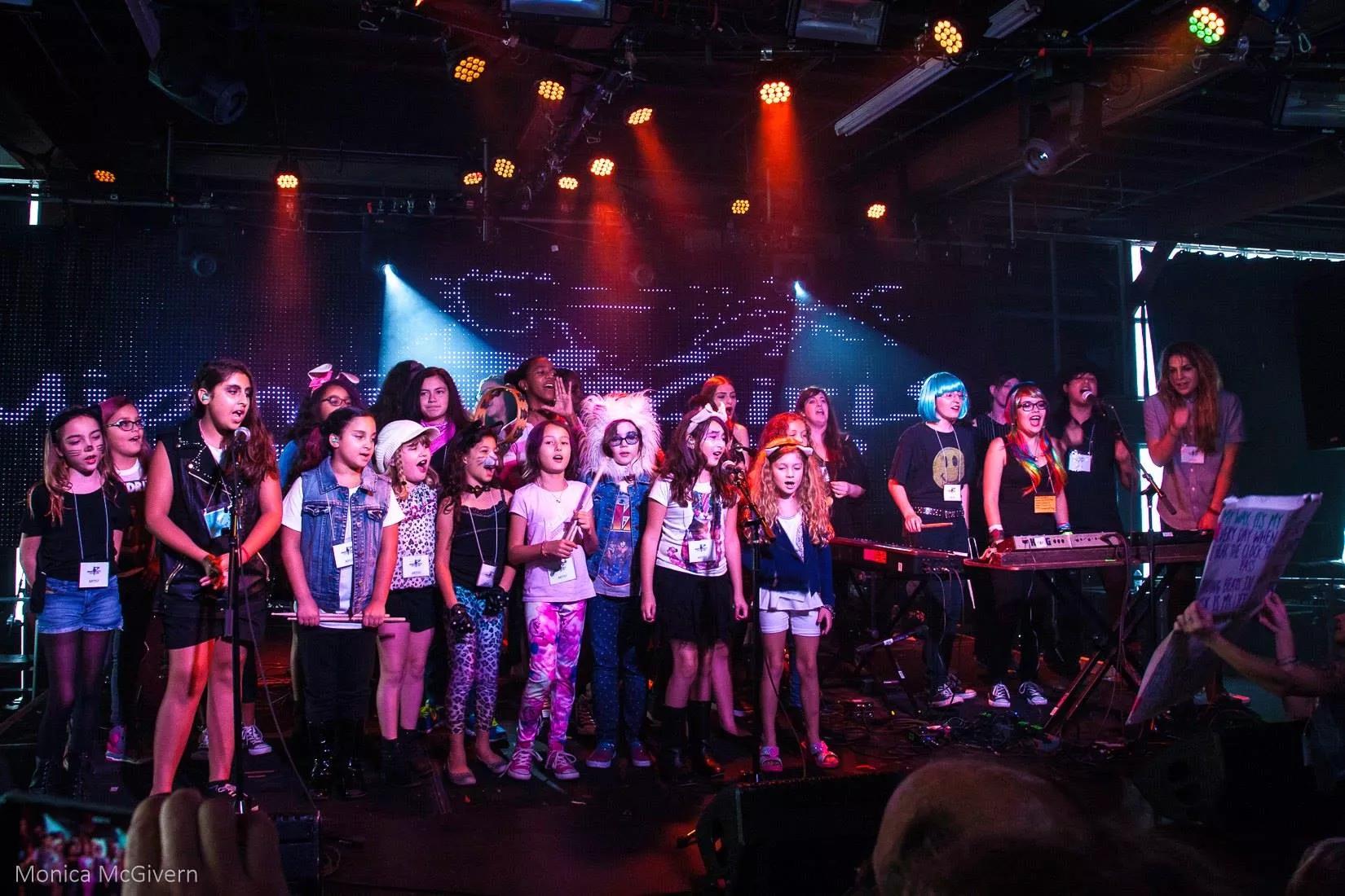 Photo of a group of young girls posing by a stage in Miami.