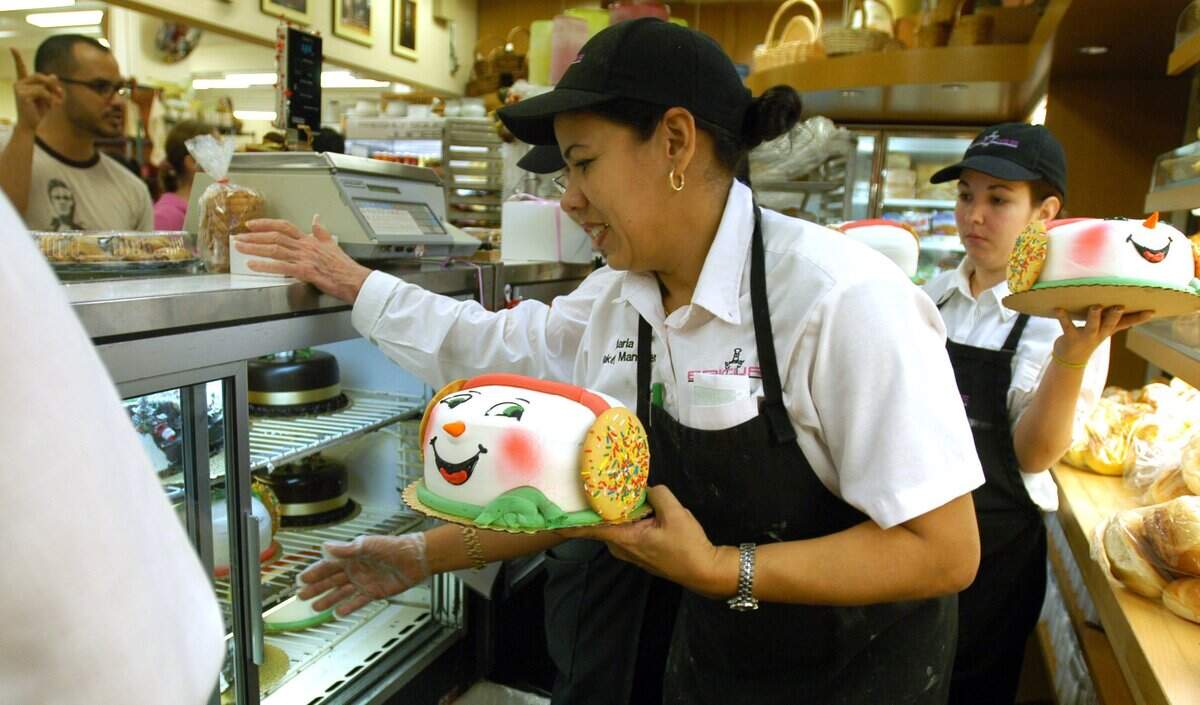 At the Epicure bakery section in 2004, workers help customers with their orders of Santa cakes for the holidays.