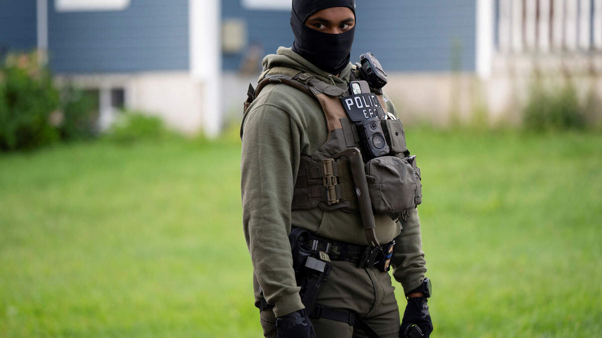 An Immigration and Customs Enforcement agent stands by as an individual is detained outside a home in Danbury, Connecticut, on Aug. 27, 2026.