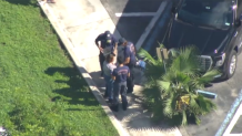 Paramedics check out a woman after a carjacking at Palmetto Hospital in Hialeah.