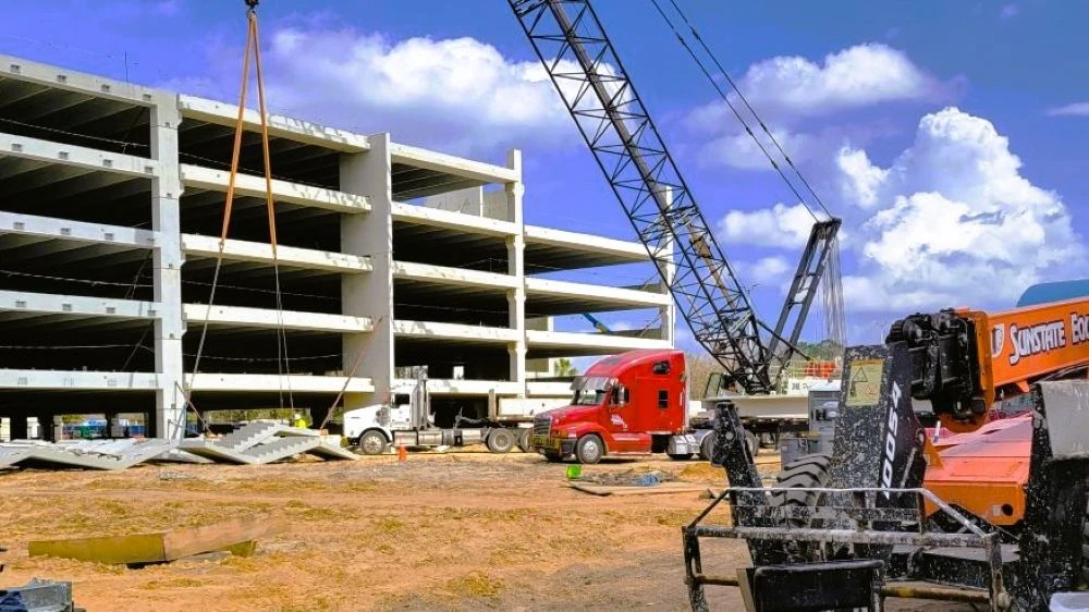 A construction crane works on a parking garage under construction at Jacksonville International Airport.