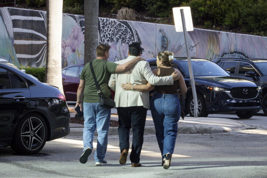 People embrace as they leave the Miami Immigration Court.