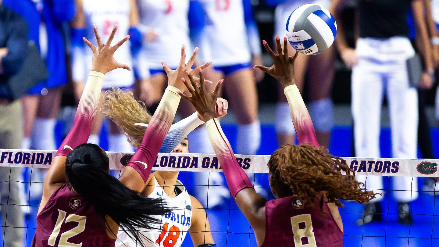 Florida Gators outside hitter Kennedy Martin (18) spikes the ball through the hands of Florida St. outside hitter Kyleene Filimaua (12) and Florida St. middle blocker Khori Louis (8) in the first set at Exactech Arena at The Stephen C O'Connell Center in Gainesville, FL on Tuesday, September 17, 2024 against the Florida State Seminoles. [Doug Engle/Gainesville Sun]