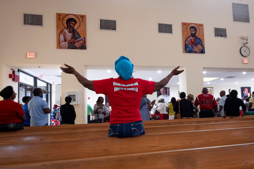 A woman raises her hands in prayer during a St. Michel prayer gathering at Notre Dame d'Haiti Catholic Church on Wednesday, Sept. 2, 2026, in the Little Haiti neighborhood of Miami, Fla.