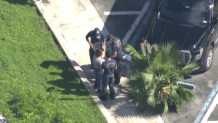 Paramedics check out a woman after a carjacking at Palmetto Hospital in Hialeah.