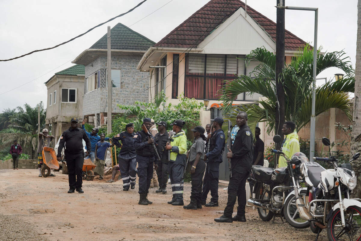 Security guards stand outside a building in Marshall, a small beach town near Roberts International Airport, as deportees from the United States arrive in Liberia, August 20, 2026.