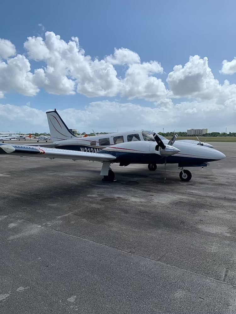 A PA-34 Piper five-seater aircraft, bearing tail number N212ML, is pictured on an airfield.