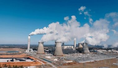 An aerial view shows a coal-fired power plant with cooling towers and smokestacks. Photo: Kelly / Pexels